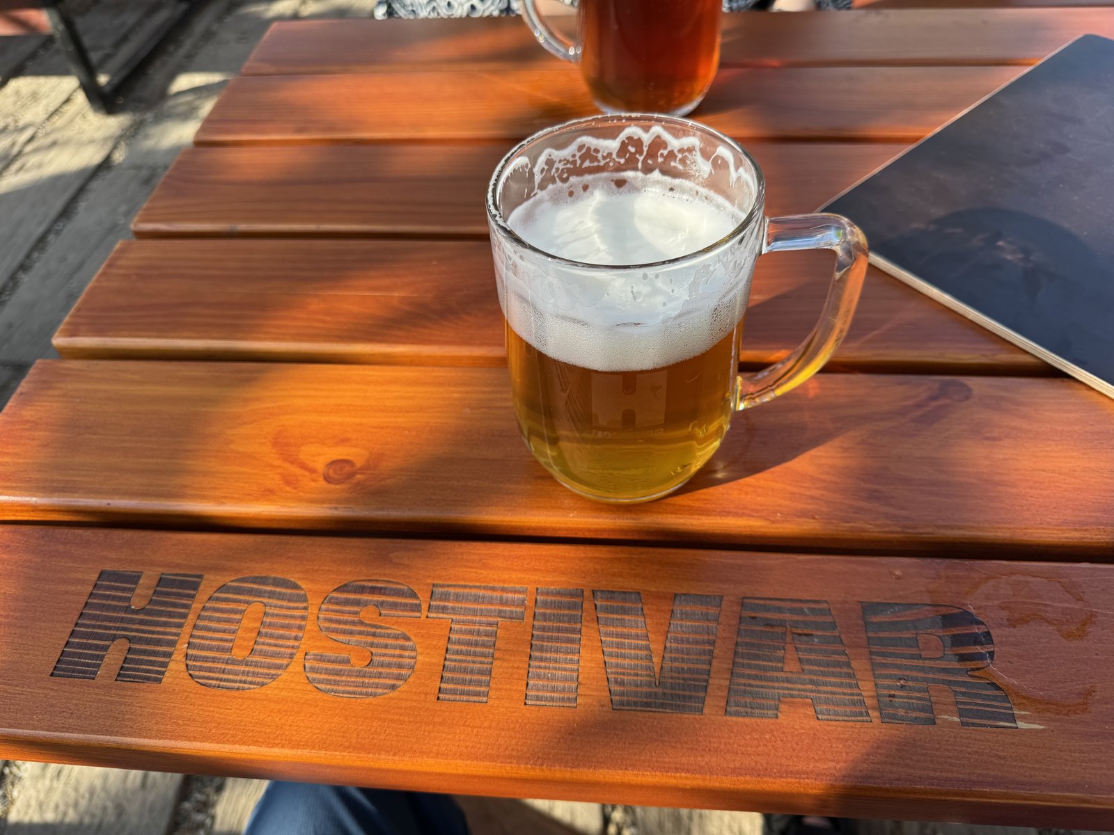 Zahrádka pivovaru vhodná pro rodiny s dětmi, pivo na stole a dostatek prostoru kolem.