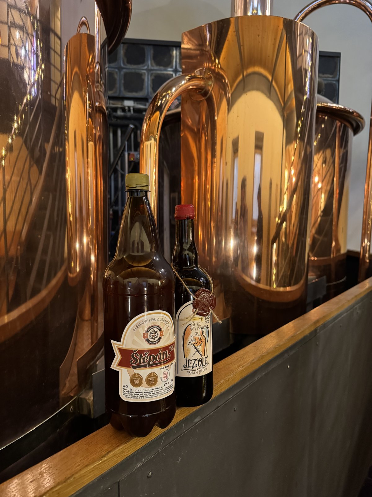 Lahvové speciály na pozadí měděných varen. Design i atmosféra fungují na jedničku.