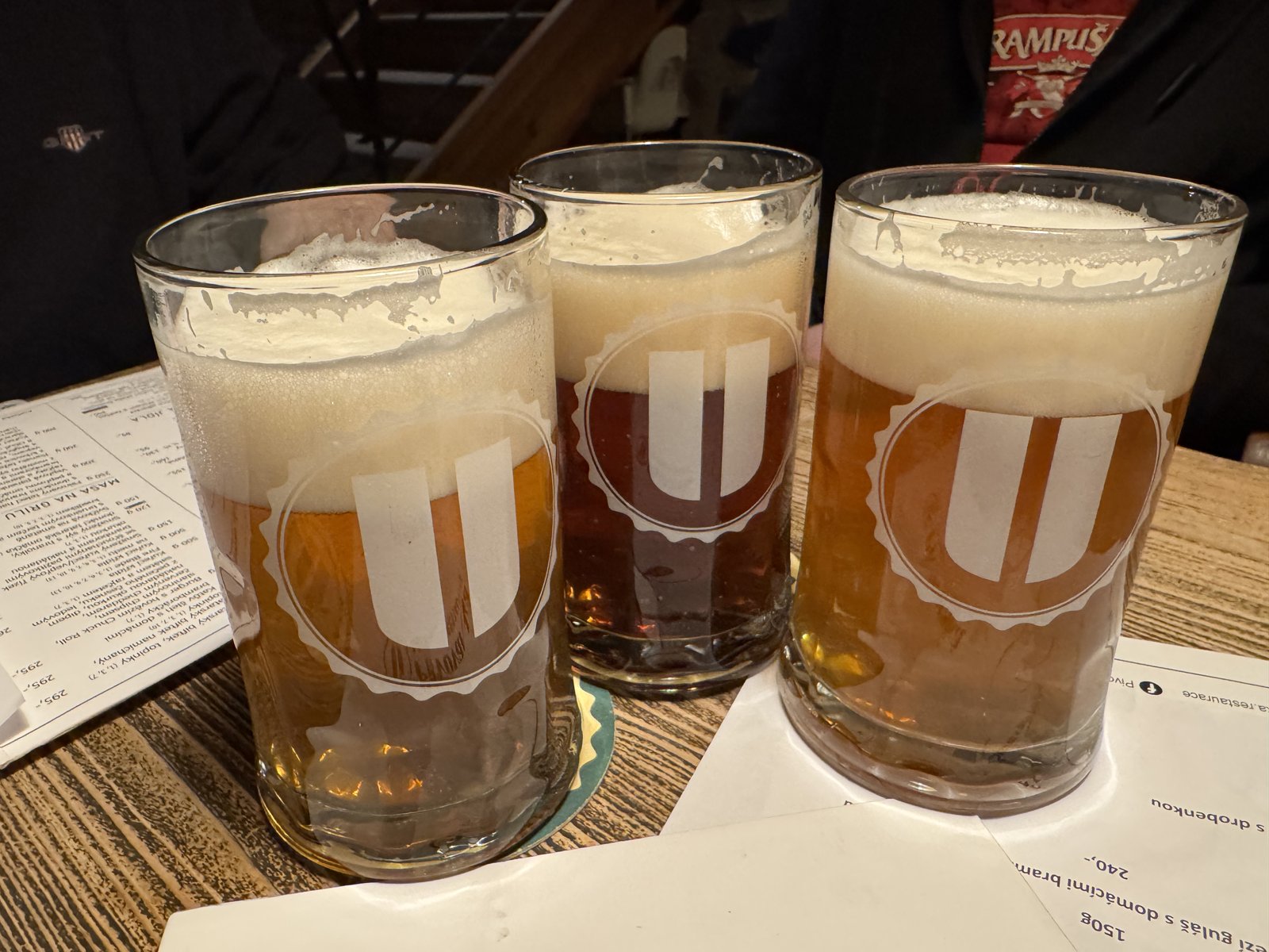 Degustační sklenice piva na stole s menu Pivovarská zahradní restaurace Uhříněves
