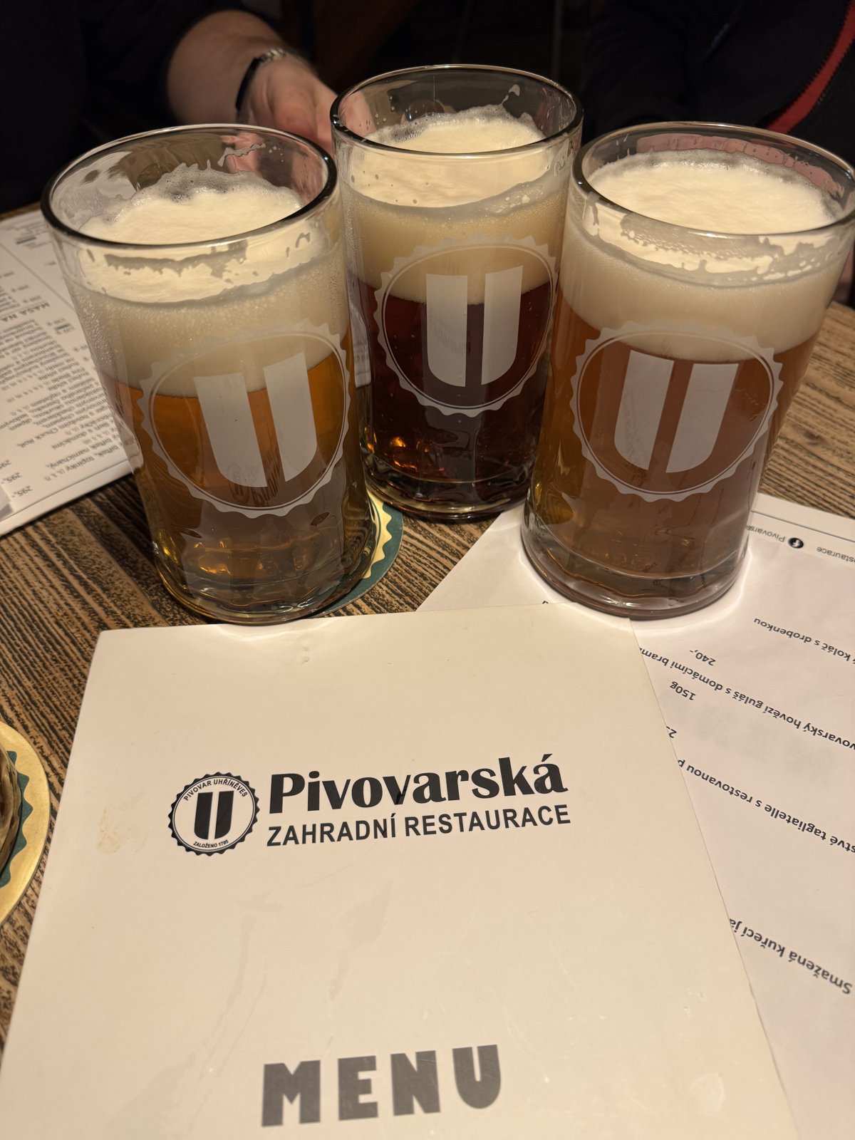 Tři degustační piva v pivovarské zahradní restauraci Uhříněves s logem pivovaru na skle