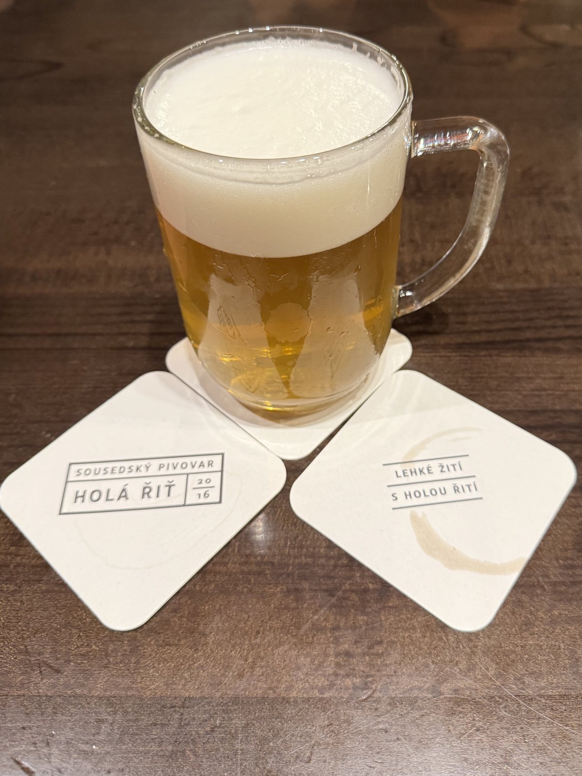 Světlé pivo z pivovaru Holá řiť ve sklenici na stole v hospodě Lidový dům Uhříněves