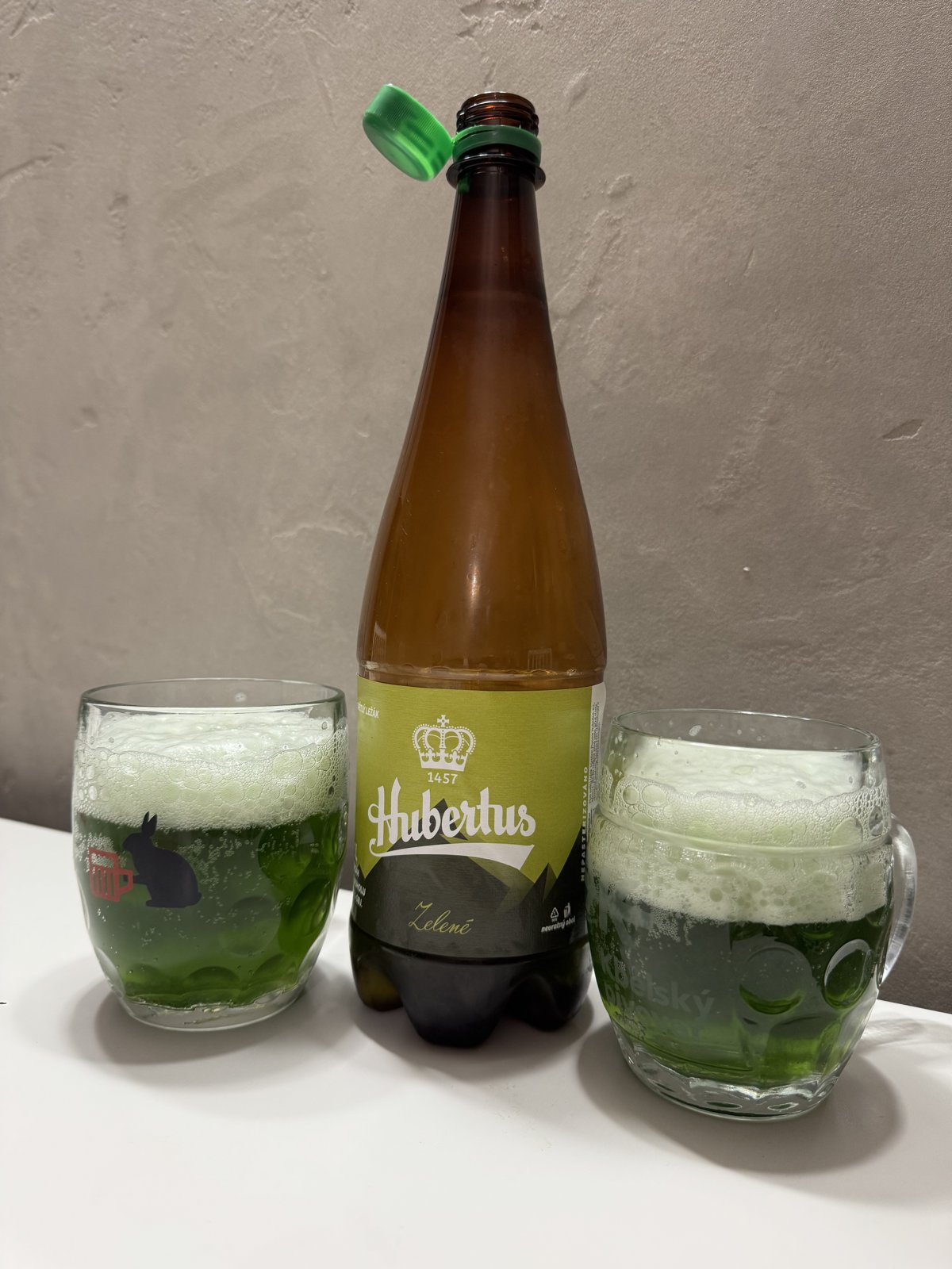 Zelené pivo Hubertus ve sklenici vedle lahve