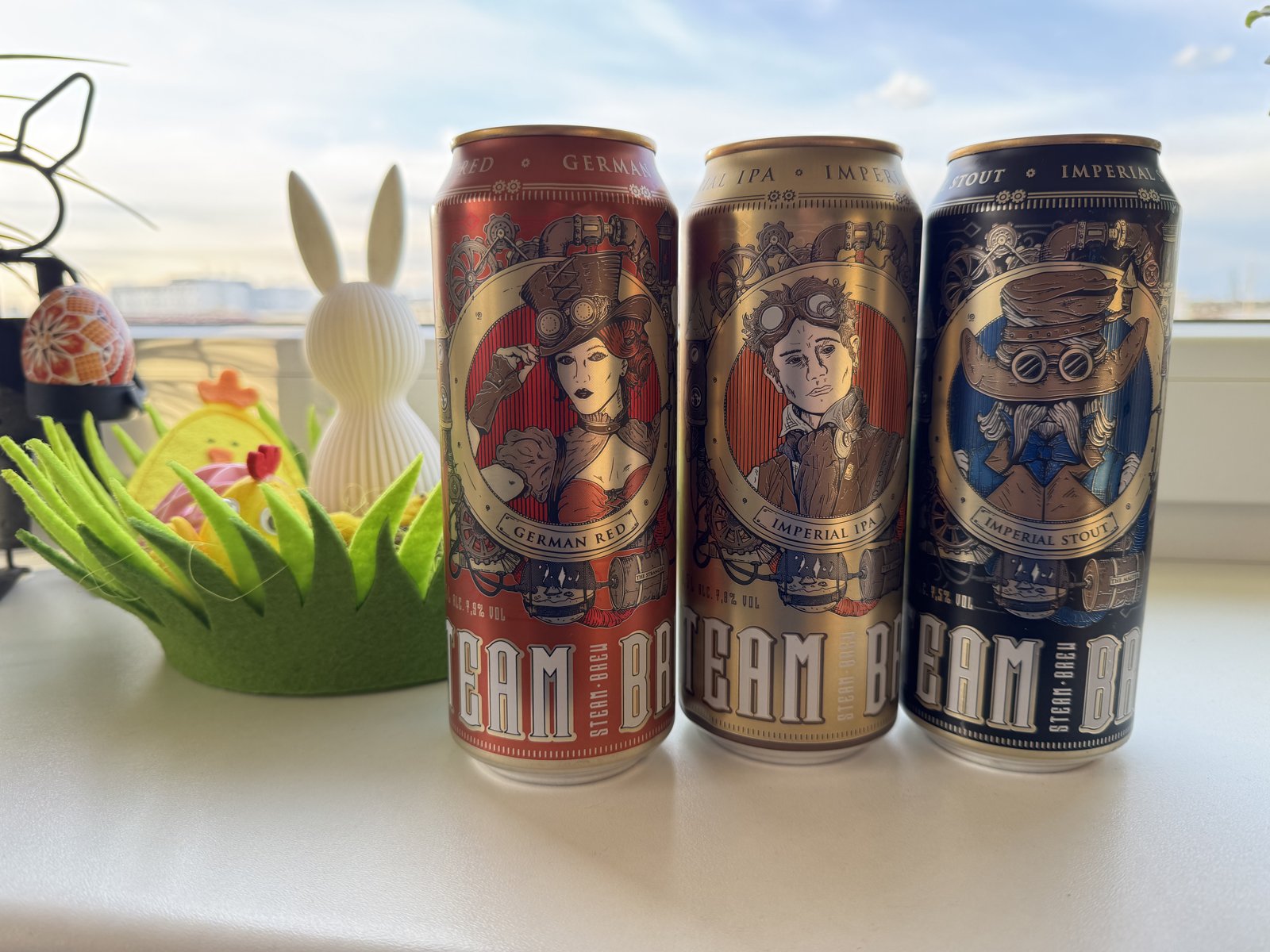 Plechovky Steam Brew German Red, Imperial IPA a Imperial Stout na stole