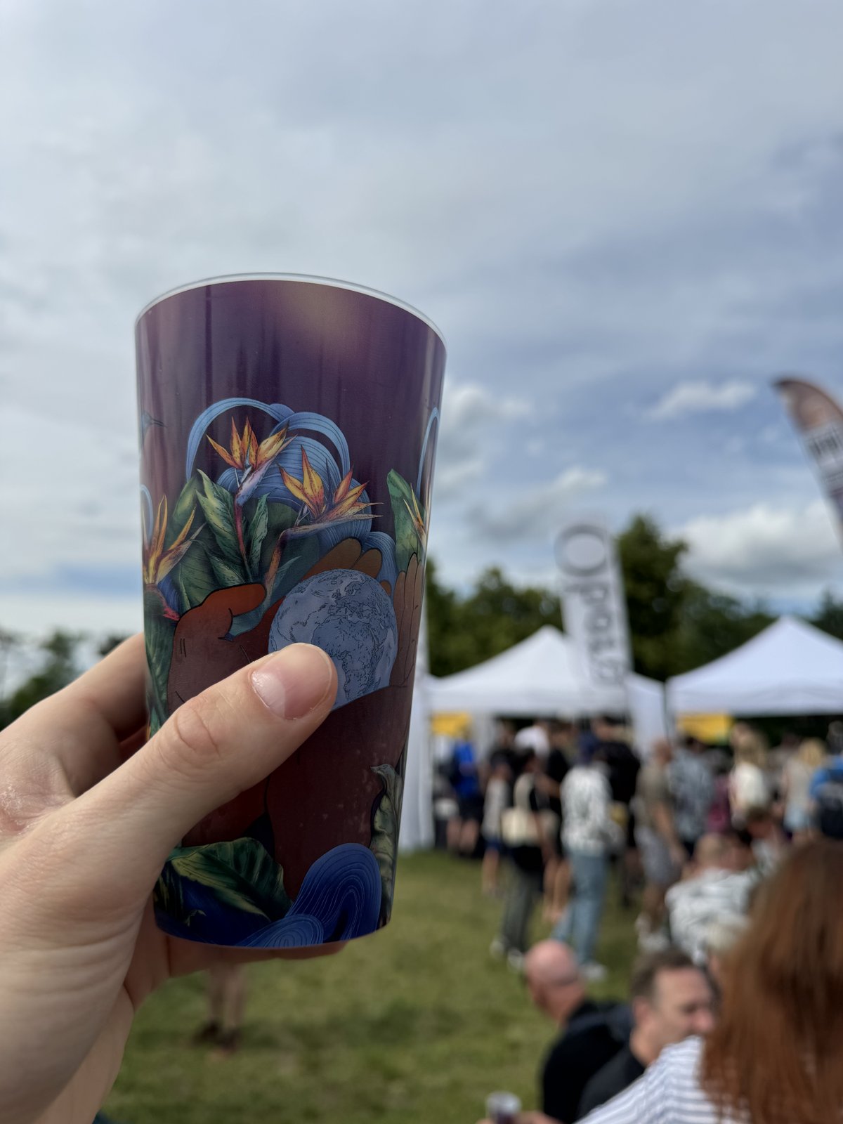 Degustační kelímek na Beerfestu na Parukářce s pivními stánky v pozadí