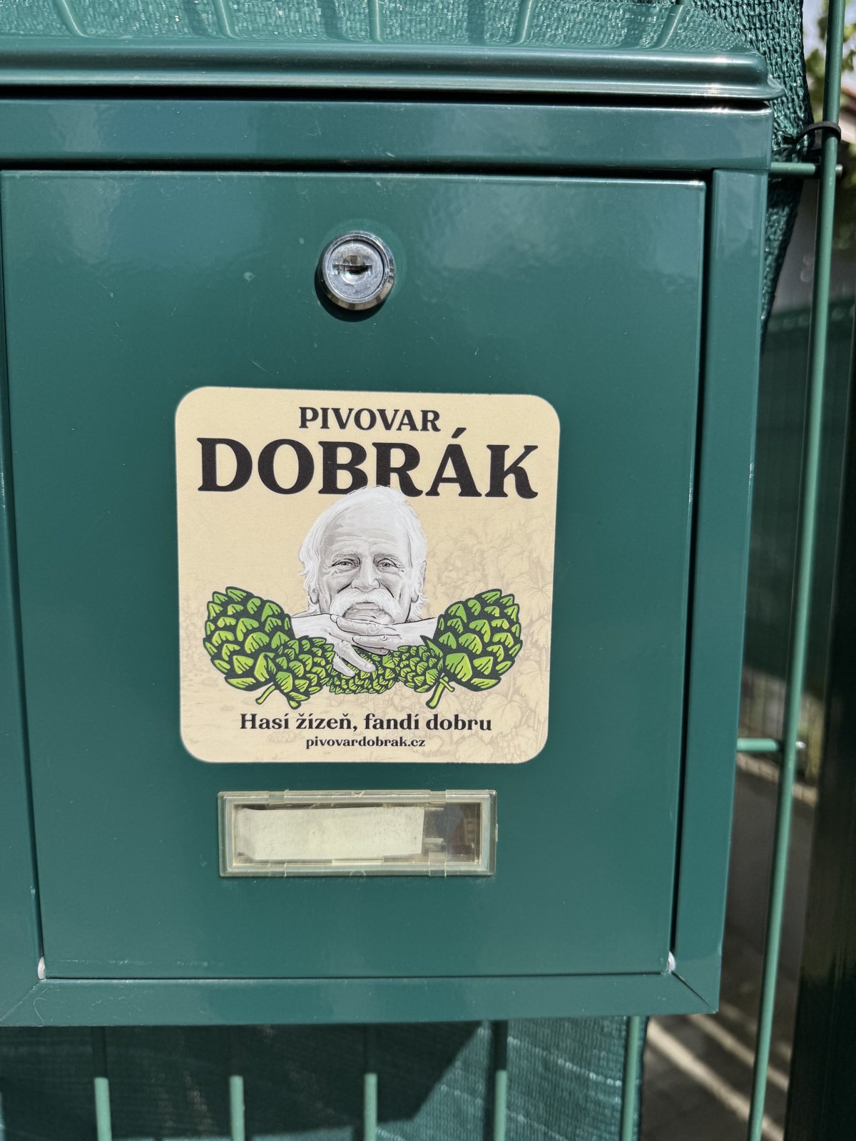 Cedule Pivovar Dobrák na zelených vratech provozovny v Nymburce