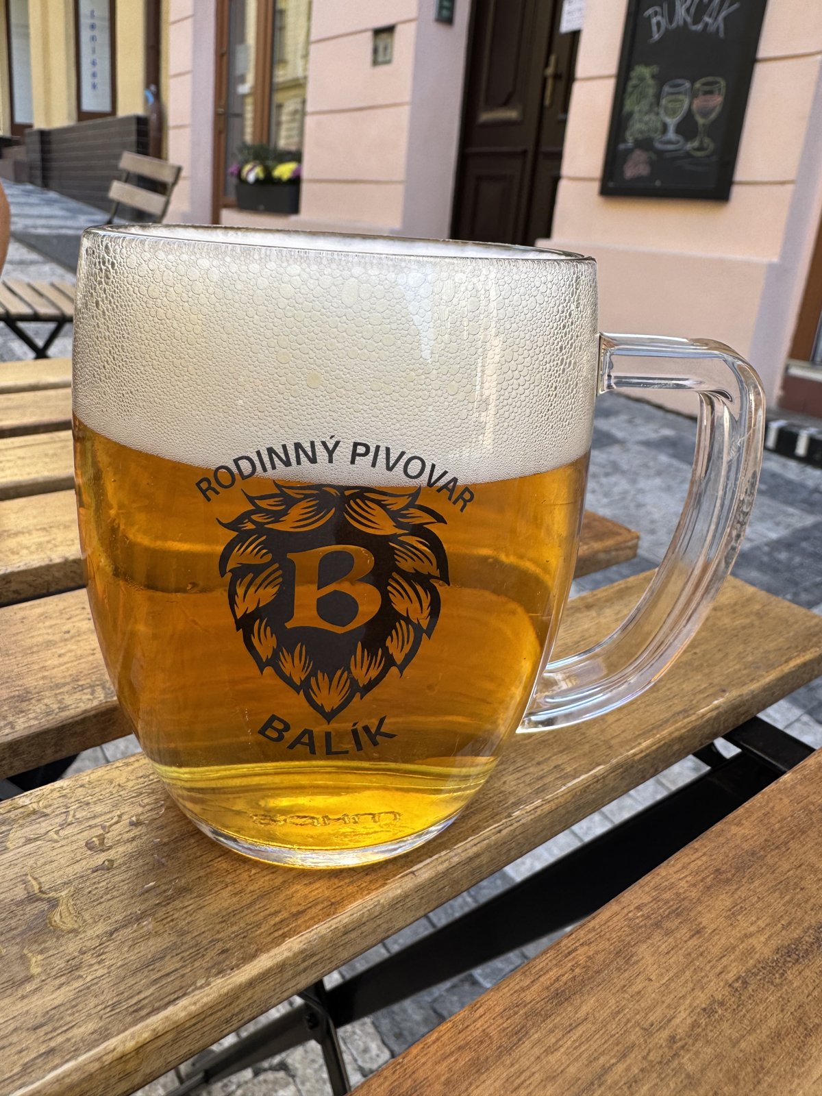 IPL pivo z Pivovaru Balík ve sklenici na venkovním posezení ve Vinotéce u Grébovky v Praze
